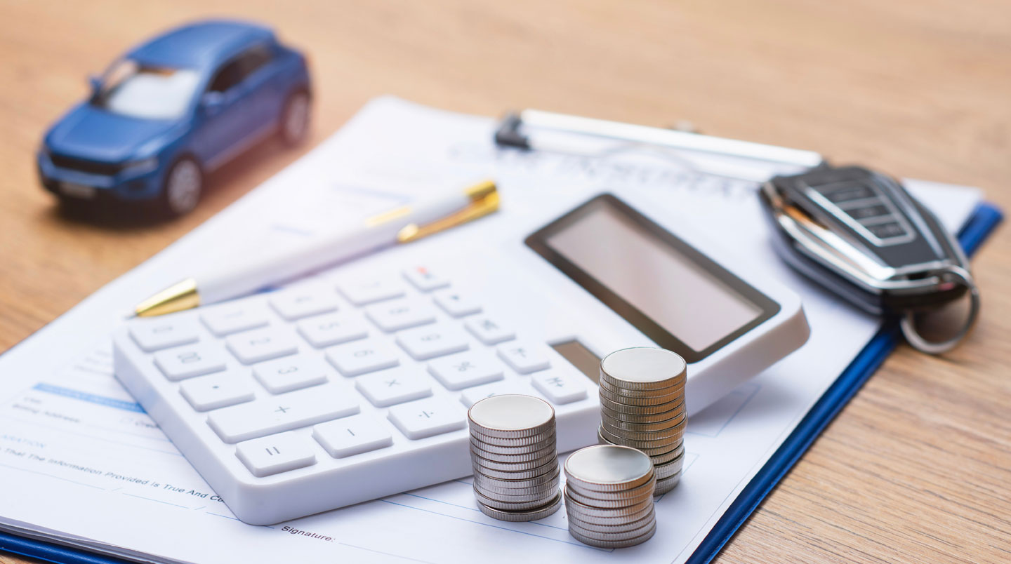 Femme professionnelle assise à son bureau consultant des contrats de location LLD et LOA avec ordinateur portable affichant des simulations financières et calculatrice